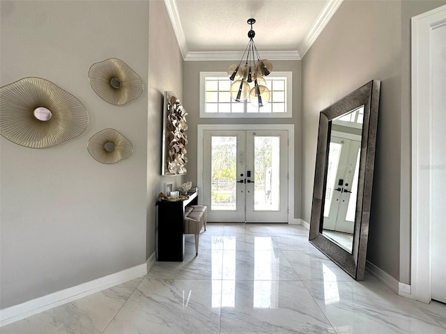 entryway with french doors, light marble finish flooring, crown molding, baseboards, and a towering ceiling