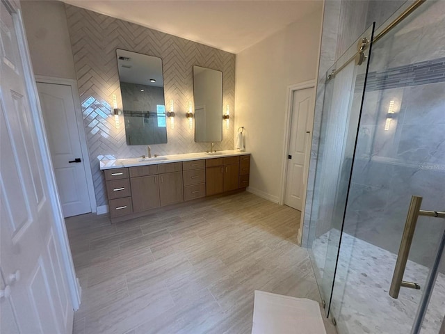 bathroom featuring a stall shower, double vanity, and baseboards