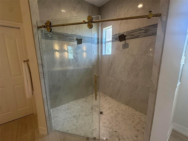 bathroom with a shower stall and baseboards