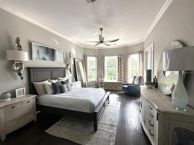 bedroom featuring a textured ceiling, dark wood-type flooring, ornamental molding, and ceiling fan