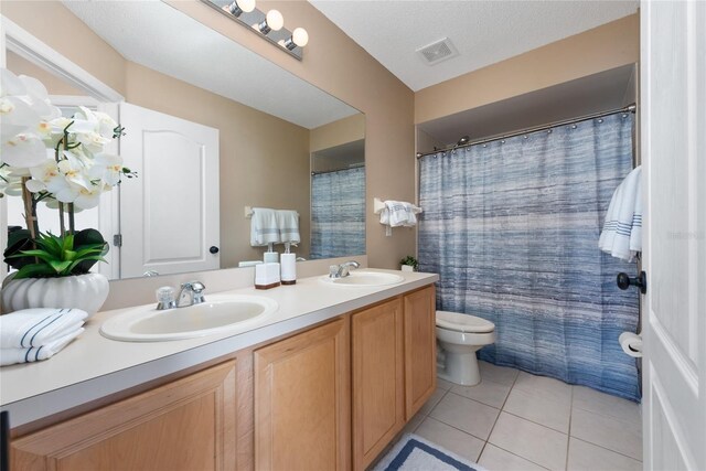 5007 Bellthorn Dr, Orlando, FL 32837 - bathroom with double vanity, toilet, and tile patterned flooring