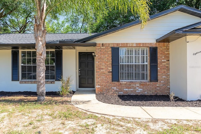 18 Palmira Rd, Debary, FL 32713 - doorway to property featuring a shingled roof and brick siding