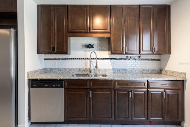 18 Palmira Rd, Debary, FL 32713 - kitchen featuring appliances with stainless steel finishes, a sink, dark brown cabinetry, decorative backsplash, and light stone countertops
