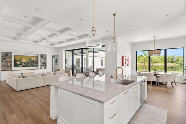 kitchen with a sink, beamed ceiling, light wood-type flooring, dishwasher, and a chandelier