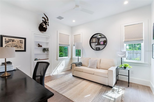 office with wood finished floors, recessed lighting, baseboards, built in shelves, and ceiling fan