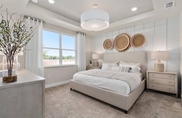 carpeted bedroom with a tray ceiling, baseboards, and recessed lighting