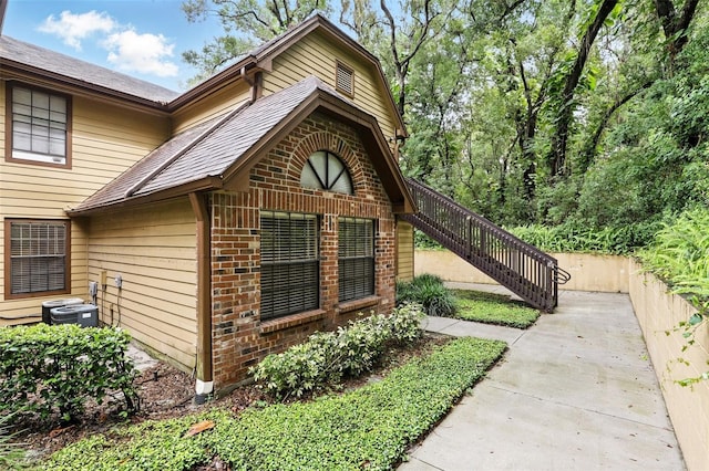 485 Forestway Cir Unit 108, Altamonte Springs, FL 32701 - view of side of home with brick siding, stairway, and central air condition unit