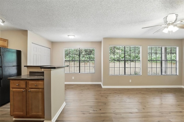 485 Forestway Cir Unit 108, Altamonte Springs, FL 32701 - kitchen featuring freestanding refrigerator, light wood-style flooring, a ceiling fan, a textured ceiling, and brown cabinetry