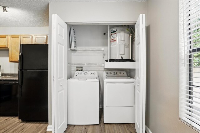 485 Forestway Cir Unit 108, Altamonte Springs, FL 32701 - clothes washing area featuring water heater, independent washer and dryer, wood finished floors, and a textured ceiling