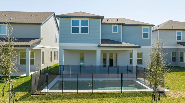 back of property featuring french doors, a patio, a lawn, roof with shingles, and stucco siding
