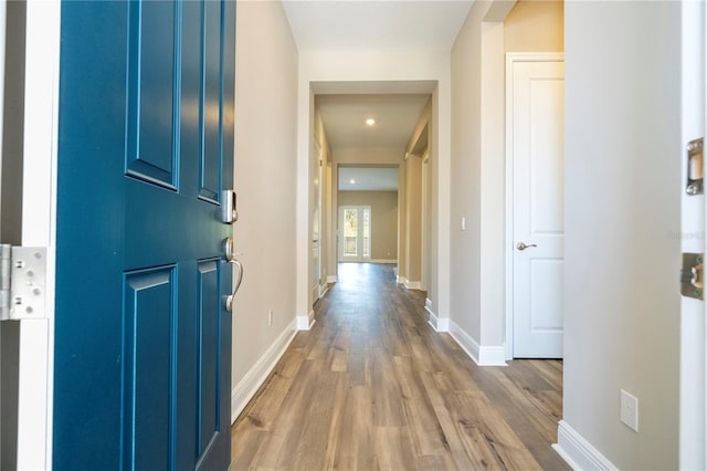 hallway with wood finished floors, baseboards, and recessed lighting