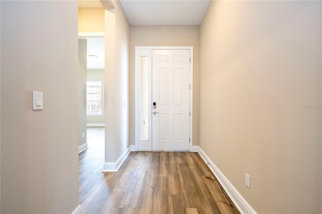 doorway featuring wood finished floors and baseboards