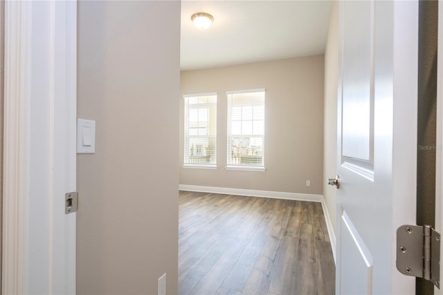 empty room featuring wood finished floors and baseboards