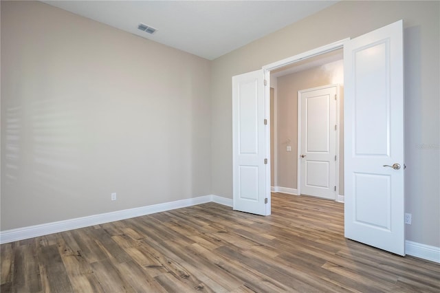 spare room with wood finished floors and baseboards