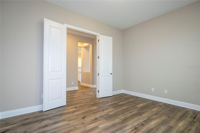 empty room with wood finished floors and baseboards