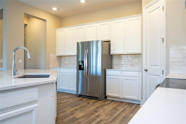 kitchen with stainless steel fridge, a sink, dark wood-style floors, white cabinetry, and tasteful backsplash