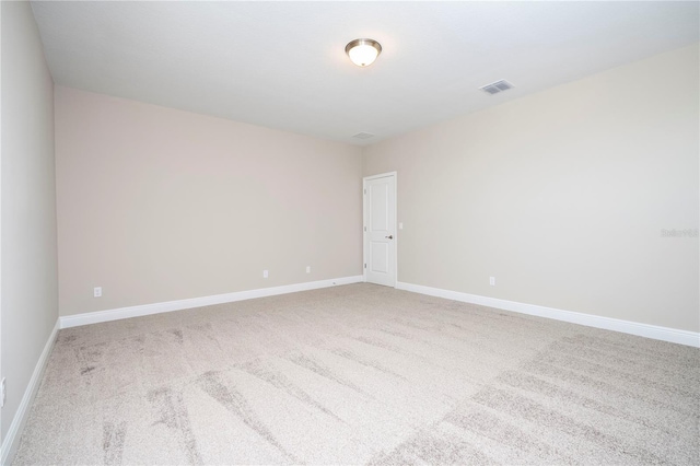 unfurnished room featuring light colored carpet and baseboards