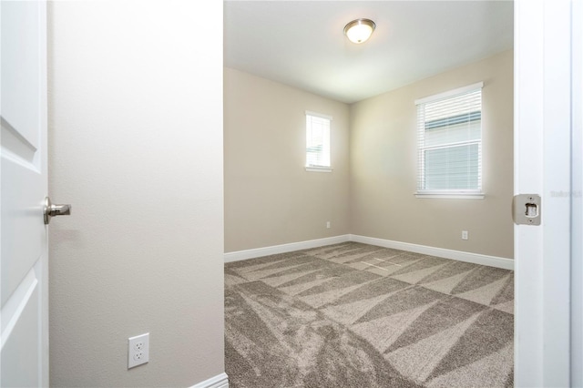 unfurnished room with carpet floors, baseboards, and plenty of natural light
