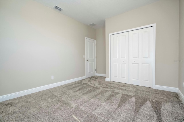 unfurnished bedroom with carpet, a closet, and baseboards