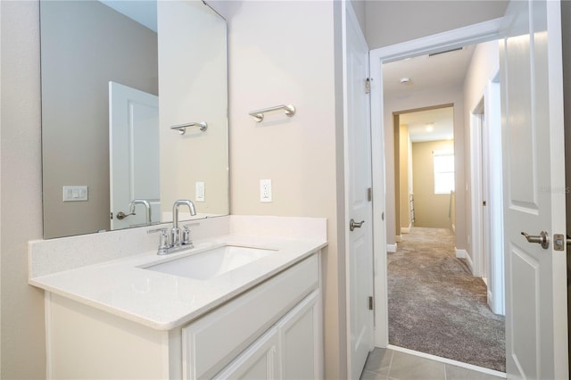 bathroom with vanity, baseboards, and tile patterned floors