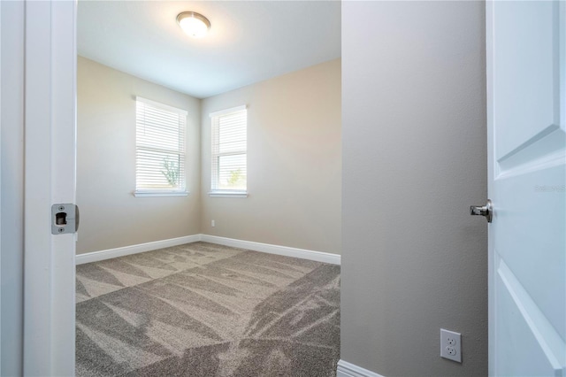 unfurnished room featuring carpet floors and baseboards