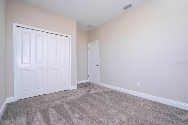 unfurnished bedroom with carpet floors, baseboards, and a closet