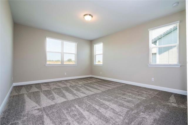 unfurnished room featuring carpet flooring, baseboards, and a smoke detector
