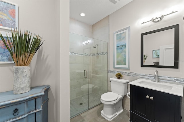 1455 Kelso Blvd, Windermere, FL 34786 - bathroom with toilet, vanity, a shower stall, tile walls, and recessed lighting