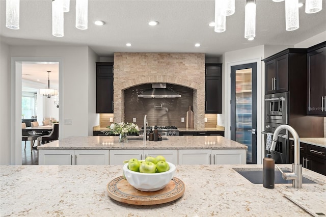 1455 Kelso Blvd, Windermere, FL 34786 - kitchen featuring stainless steel microwave, a sink, backsplash, a chandelier, and wall chimney range hood