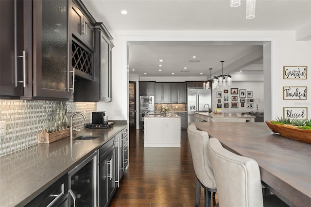 1455 Kelso Blvd, Windermere, FL 34786 - kitchen featuring a sink, wine cooler, built in appliances, dark wood-style floors, and decorative backsplash