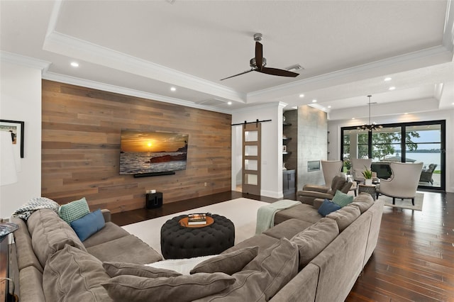 1455 Kelso Blvd, Windermere, FL 34786 - living area featuring a tray ceiling, a barn door, an accent wall, wood walls, and ornamental molding