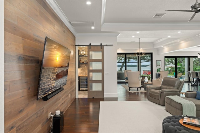 1455 Kelso Blvd, Windermere, FL 34786 - living room with wine cooler, a barn door, recessed lighting, ornamental molding, and dark wood-style flooring