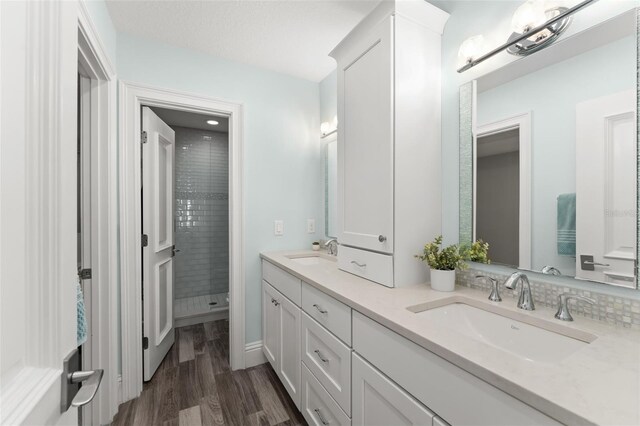 1455 Kelso Blvd, Windermere, FL 34786 - full bathroom featuring double vanity, wood finished floors, and tiled shower