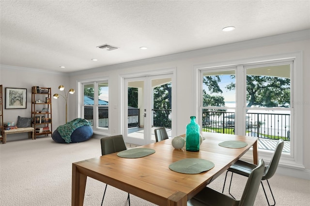 1455 Kelso Blvd, Windermere, FL 34786 - dining space with light carpet, french doors, ornamental molding, and a textured ceiling