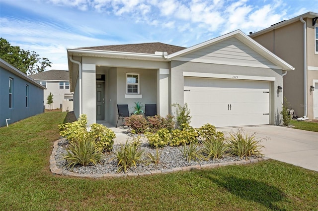 view of front facade with stucco siding, driveway, a front lawn, and an attached garage
