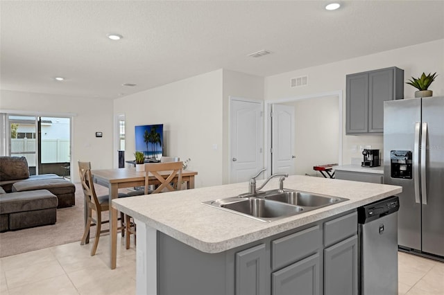kitchen with appliances with stainless steel finishes, a sink, gray cabinets, light tile patterned flooring, and recessed lighting