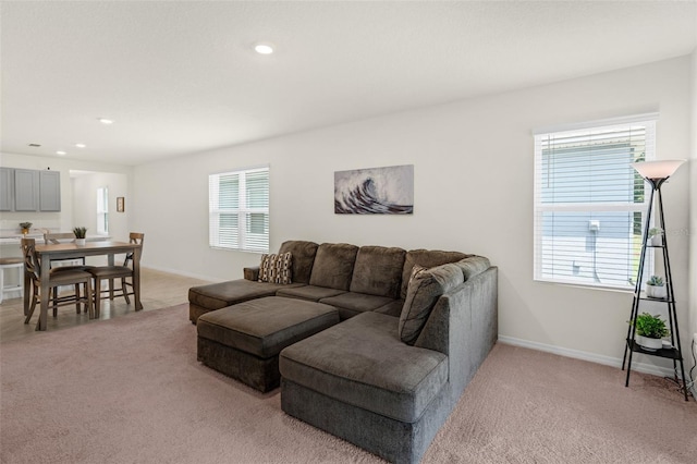living area featuring light colored carpet, plenty of natural light, recessed lighting, and baseboards
