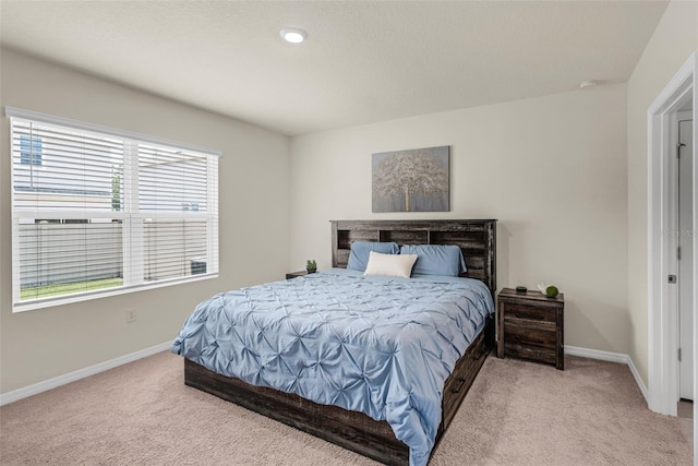 bedroom featuring light colored carpet and baseboards