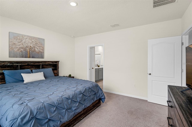 bedroom featuring carpet floors, baseboards, and ensuite bath