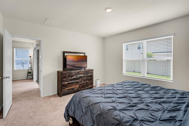 bedroom with light colored carpet and baseboards