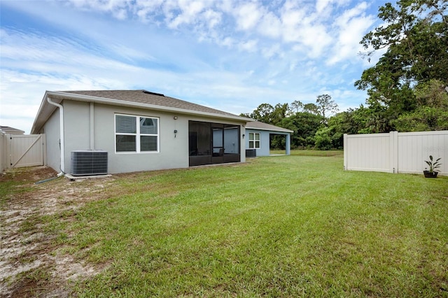 back of house featuring central air condition unit, a sunroom, a gate, and stucco siding