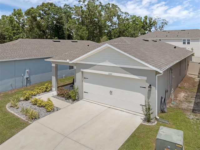 view of front of property with a garage, concrete driveway, stucco siding, and roof with shingles