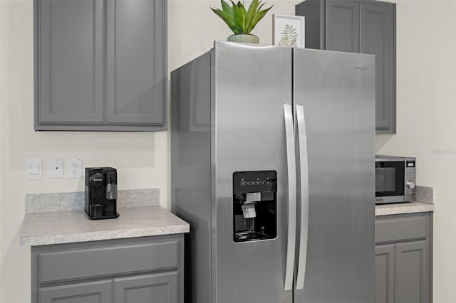 kitchen with appliances with stainless steel finishes, gray cabinetry, and light countertops