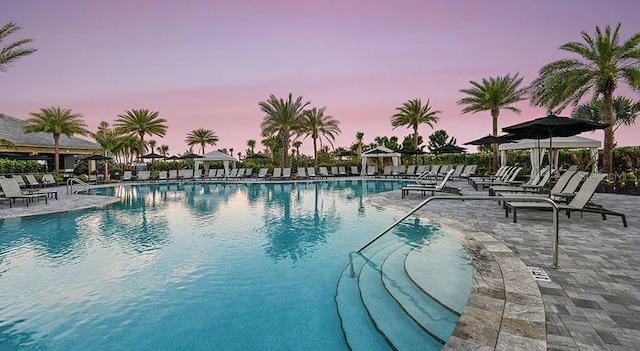 5658 Nevis Ter, Kissimmee, FL 34758 - pool at dusk featuring a community pool and a patio area