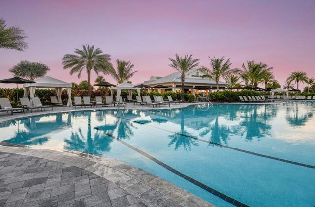 5658 Nevis Ter, Kissimmee, FL 34758 - pool at dusk featuring a gazebo, a community pool, and a patio