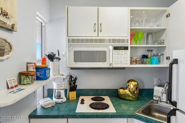935 S Atlantic Ave Unit 355, Daytona Beach, FL 32118 - kitchen view of white appliances, white cabinetry, and open shelves