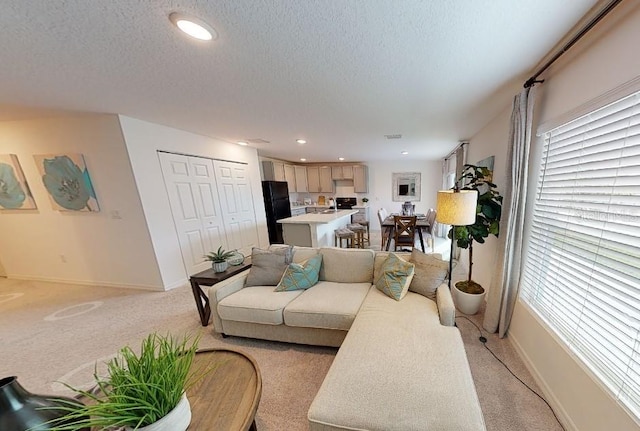 living room with light carpet, baseboards, a textured ceiling, and recessed lighting
