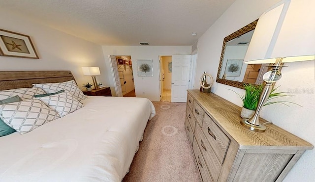 bedroom featuring light carpet and a textured ceiling