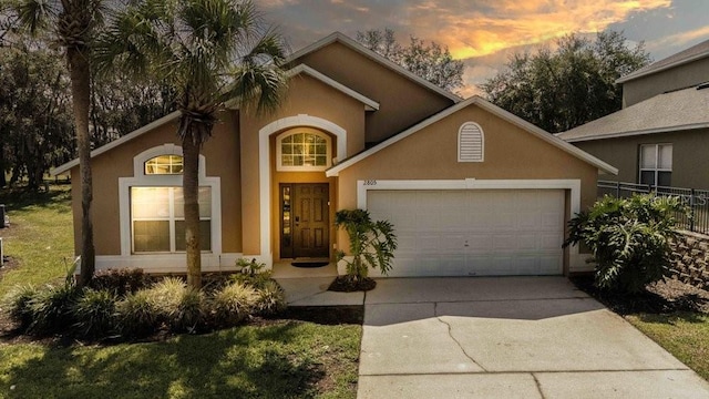 2805 Lido Key Ct, Kissimmee, FL 34747 - view of front facade featuring a garage, stucco siding, driveway, and fence