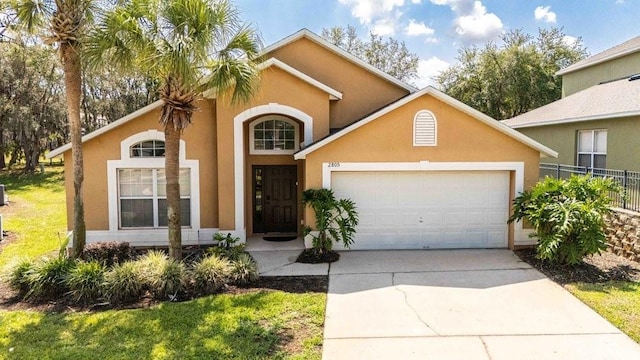 2805 Lido Key Ct, Kissimmee, FL 34747 - view of front facade with an attached garage, driveway, stucco siding, and fence